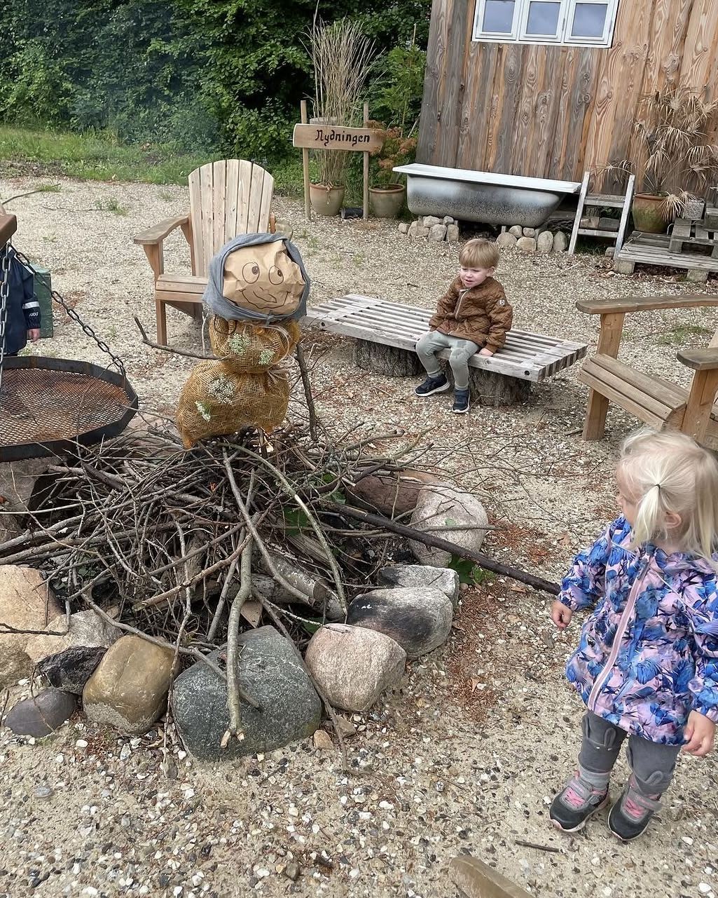 Barn i regntøj og gummistøvler ude i haven